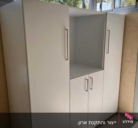 ארון לבן עם ידיות מתכת בחדר מואר